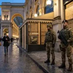 Italian soldiers guard a boarded luxury gallery in Milan during protests