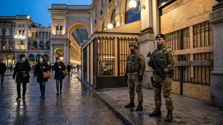 Italian soldiers guard a boarded luxury gallery in Milan during protests